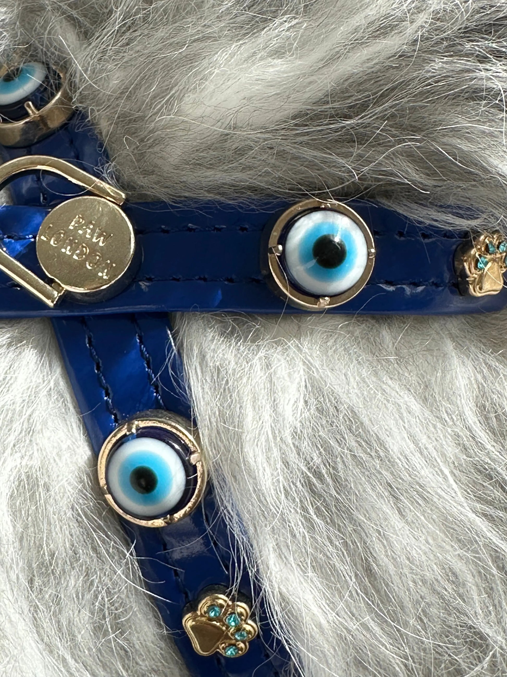 Close-up of the Evil Eye Dog Harness by PAW LONDON in royal blue, showcasing the signature evil eye stones and luxurious gold-plated accents, perfect for adding style and protection to your pet.